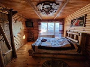 - une chambre avec un lit dans une cabane en rondins dans l'établissement Гуцульська хата, à Yaremtche