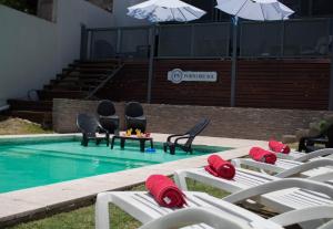 - une piscine avec des chaises longues et une table dans l'eau dans l'établissement Apart Porto del Sol by CPH, à Villa Carlos Paz