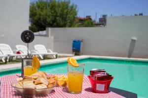 - une table avec une assiette de pain et de jus d'orange dans l'établissement Apart Porto del Sol by CPH, à Villa Carlos Paz