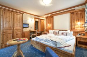 - une chambre avec un grand lit et une table dans l'établissement Hotel Gianna, à Madonna di Campiglio