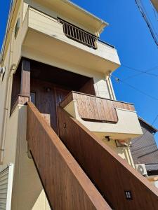 ein Haus mit einem Holzzaun und einer Tür in der Unterkunft Tiz wan 明石大橋 in Awaji