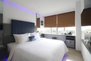 a bedroom with a large white bed with a blue headboard at Moritz Biz Gandaria in Jakarta