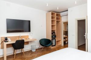 a bedroom with a desk and two chairs and a television at Hotel Casa Luxemburg- Newly Renovated in Sibiu