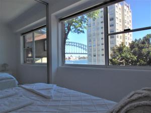 - une chambre avec un lit et une fenêtre donnant sur un pont dans l'établissement Spectacular Views of Sydney Harbour with Free Parking, à Sydney