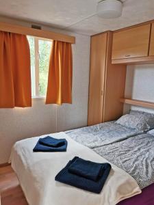 1 dormitorio con 2 toallas en una cama en Keja Domki Chłapowo, en Władysławowo