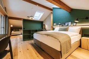 - une chambre avec un grand lit et un mur vert dans l'établissement Hotel Fiescherblick, à Grindelwald