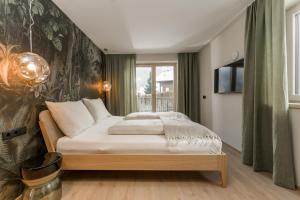 1 dormitorio con 1 cama y TV en la pared en CHILL HOUSE, en Schladming