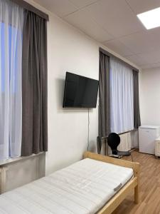 una camera con letto e TV a schermo piatto di Central Hostel Jelgava a Jelgava