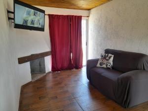 a living room with a couch and a red curtain at Solar de la Viuda in Punta Del Diablo