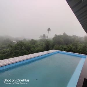 une piscine sur le toit d'un bâtiment avec une forêt brumeuse dans l'établissement Airspace villa, à Igatpuri