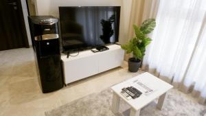 RELOhomes Serviced Apartment في مومباي: تلفزيون بشاشة مسطحة جالس فوق مركز ترفيه ابيض