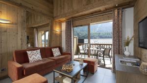 een woonkamer met een bank en een tafel bij MGM Hôtels & Résidences - Résidence Alexane in Samoëns