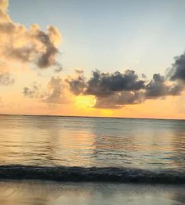 un tramonto sulla spiaggia con l'oceano e le nuvole di The hayce residence a Kilifi