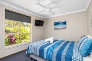 een slaapkamer met een bed en een raam bij Aqua Lagoon - Great Family Beach Getaway in Nelson Bay