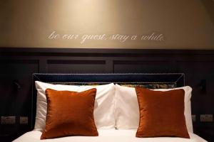 un lit avec tête de lit et citation au-dessus dans l'établissement The Coachman Hotel, à Kilsyth