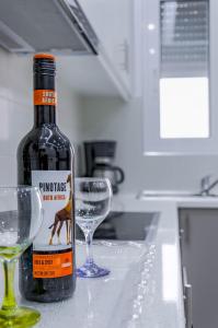 - une bouteille de vin assise à côté de deux verres sur un comptoir dans l'établissement Renovated 2BD house close to Pireus port, au Pirée