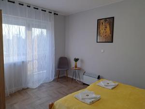 um quarto com uma cama amarela e uma janela em Apartments Manna Palic em Palić