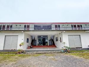 a white house with a porch and a balcony at OYO 92090 Panorama Rinjani Lodge in Labuan Lombok