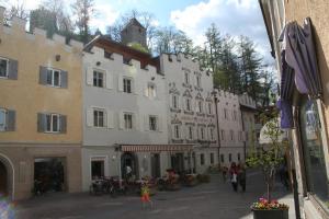 um grupo de edifícios em uma rua com pessoas andando em Hotel Krone em Brunico