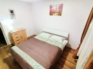 a small bedroom with a bed and a wooden floor at Apartament Cetate in Alba Iulia