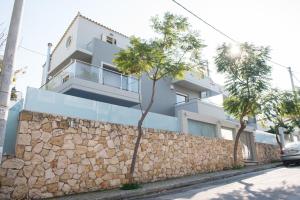 een wit huis met een stenen muur en bomen bij Palmyra Athens in Athene