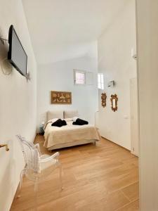 um quarto branco com uma cama e uma cadeira em Home Viale Trento 16 em Cagliari