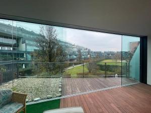 balcón con vistas a una terraza de madera en Esclusivo loft con winter-garden, en Assago