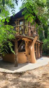 una pequeña casa de madera con un árbol en Casita de Duendes, en Salinas