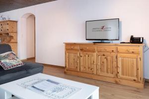 un soggiorno con TV sopra un armadio in legno di Apartment Jungfrau Lodge a Grindelwald