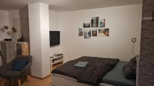 a small bedroom with a bed and a chair at Schöne Souterrain Wohnung (WLAN/Parken kostenlos) in Riegel