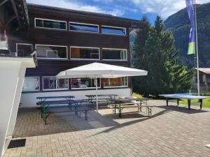 un edificio con tavoli da picnic e un ombrello di Ferienhaus Davos "Ob dem See" a Davos