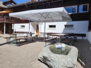 patio con tavolo e ombrellone di Ferienhaus Davos "Ob dem See" a Davos