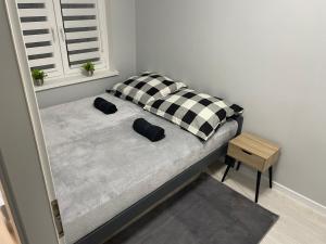 uma cama com duas almofadas num quarto em Apartament Nadbrzezna em Świdnica