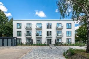 un edificio de apartamentos con balcones y un patio en Sporthotel Neuruppin - Apartmenthaus mit Ferienwohnungen, en Neuruppin