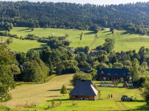 un fienile nel mezzo di un campo con alberi di Gościniec Rabe - Agro&SPA a Ustrzyki Dolne