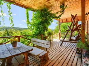 una terrazza in legno con tavolo e panca di Gościniec Rabe - Agro&SPA a Ustrzyki Dolne