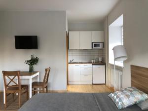 Cette chambre comprend une cuisine et une table avec un lit. dans l'établissement COMFY Patogūs namai, à Kaunas