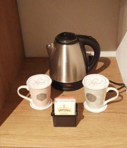 two coffee cups and a tea kettle on a table at Neoclassico by Tiziana Monaldi in Pitigliano