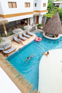 - un groupe de personnes se baignant dans une piscine d'un complexe dans l'établissement Roomates Surf Camp Canggu by Ini Vie Hospitality, à Canggu