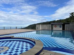 - une piscine avec des carreaux bleus sur le côté d'un bâtiment dans l'établissement Alinson Sunset Hill, à Bogor