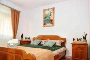 a bedroom with a wooden bed with a green blanket at Apartament Cetate in Alba Iulia