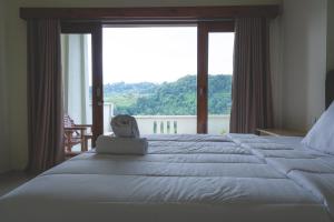 a bedroom with a large bed with a large window at GREEN RINJANI in Bayan