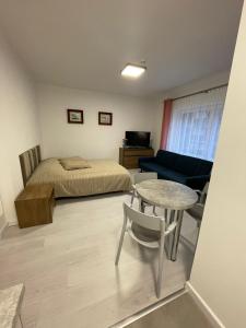 een slaapkamer met een bed, een tafel en een bank bij Apartamenty Wisła Centrum in Wisła