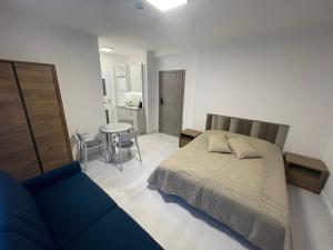 een slaapkamer met een bed en een blauwe bank bij Apartamenty Wisła Centrum in Wisła