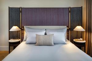 um quarto com uma cama grande e 2 candeeiros em Small Luxury Hotel Ambassador Zurich em Zurique