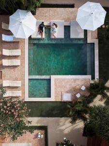 - une vue sur la piscine bordée de parasols dans l'établissement Terra Cottages Bali, à Uluwatu