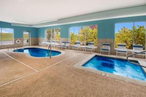 a pool in a room with chairs and a swimming pool at SureStay Plus Hotel by Best Western Jasper in Jasper