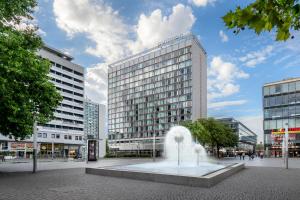 una fuente en medio de una ciudad con edificios en Occidental Dresden Newa, en Dresden