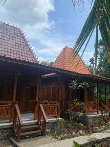 una casa con panche di legno di fronte ad essa di Nusa Penida Pudak Nature Bungalow a Nusa Penida