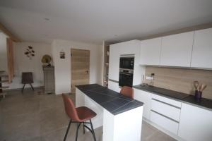 a kitchen with white cabinets and orange chairs at Charmant chalet, spacieux, proche du lac, vue sur la montagne in Gérardmer